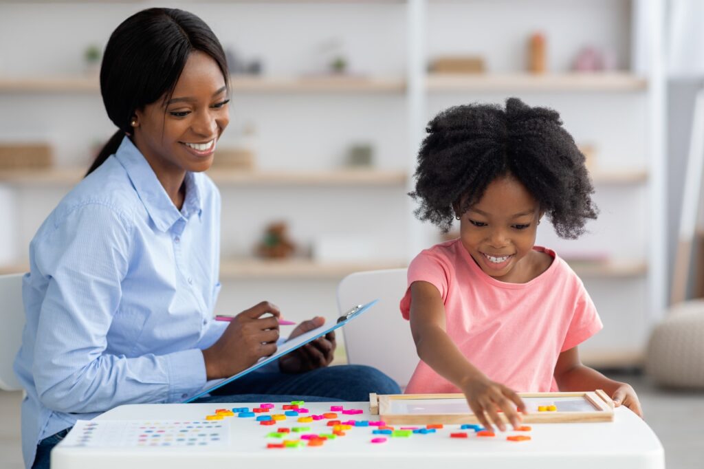 Smiling child development specialist testing cute little girl